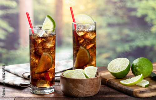 Rum and cola cocktail with lime slice