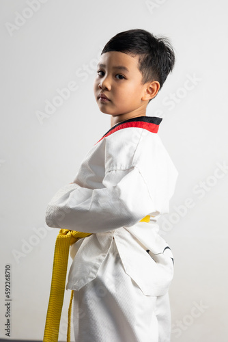 Portrait Asian boy kid karate martial arts. Taekwondo uniform with yellow belt. Asian school boy isolated on white background banner