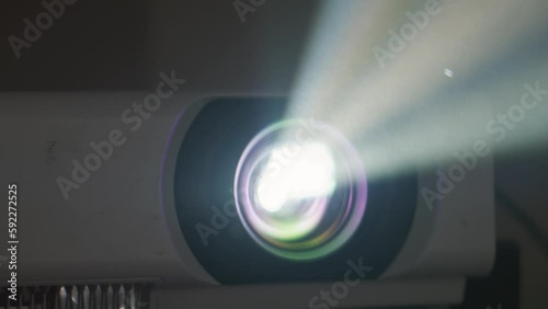 Searchlight provides bright colored beam for broadcasting picture on screen. Turned on projector demonstrates picture with colour beams photo