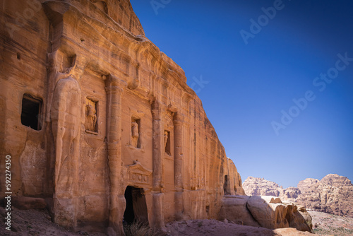 Petra w Jordanii. Ruiny starożytnego miasta w skale na tle błękitnego, bezchmurnego nieba.