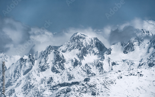 Alpine landscape with peaks covered with snow and clouds © Maksim