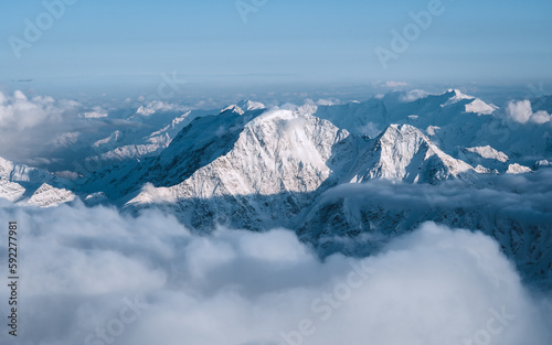 Snowy mountains in the clouds. Beautiful landscape with snowy rocks © Maksim