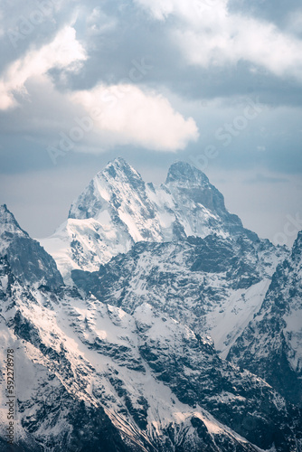 View of  Mount Ushba and snow-covered peaks on a cloudy day © Maksim