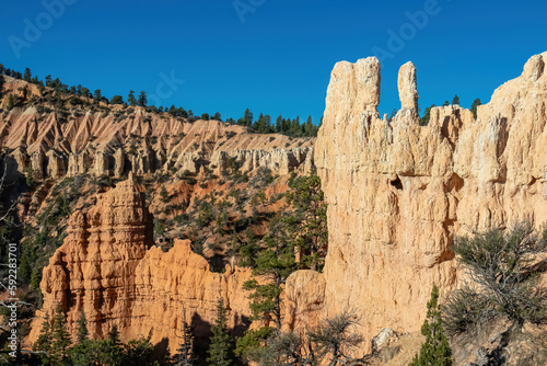Panoramic view of sandstone rock formations on Navajo Rim hiking trail in Bryce Canyon National Park, Utah, USA. Hoodoos (spire of sedimentary rock) on sunny summer day in unique natural amphitheatre photo