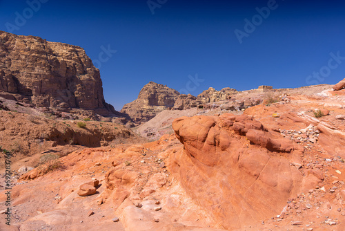 Petra w Jordanii. Pustynne formacje skalne na tle błękitnego, bezchmurnego nieba.