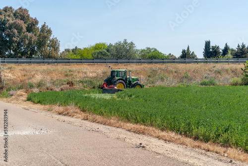 Agricultor con tractor realizando siega de forraje.