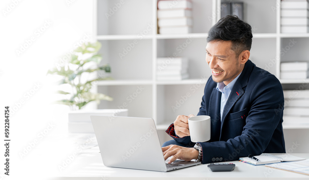 Young happy businessman woking on laptop computer, sitting at modern office. Young happy businessman woking on laptop computer, sitting at modern office.