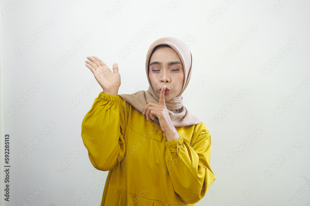 Beautiful young asian muslim woman wearing casual clothes asking to be quiet with finger on lips. silence and secret concept. Beautiful young asian muslim woman wearing casual clothes asking to be quiet with finger on lips. silence and secret concept.
