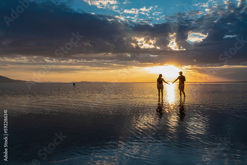 Εκτύπωση καμβά Silhouette of loving couple walking at sunrise on the salt lake of Bonneville Salt Flats, Wendover, Western Utah, USA, America