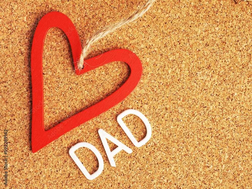 a red heart with the word dad on a pin board a red heart with the word dad on a pin board