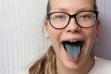 Funny portrait of a girl with a painted tongue for the Easter holidays.