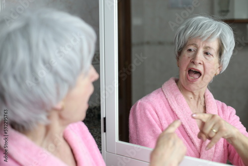 Senior woman pointing to her own reflection with pride 