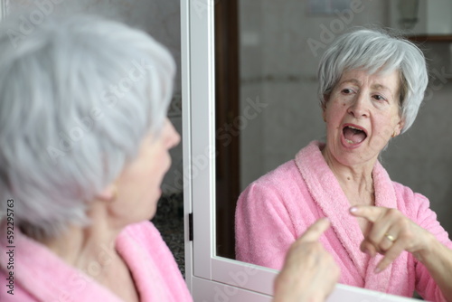 Senior woman pointing to her own reflection with pride  photo