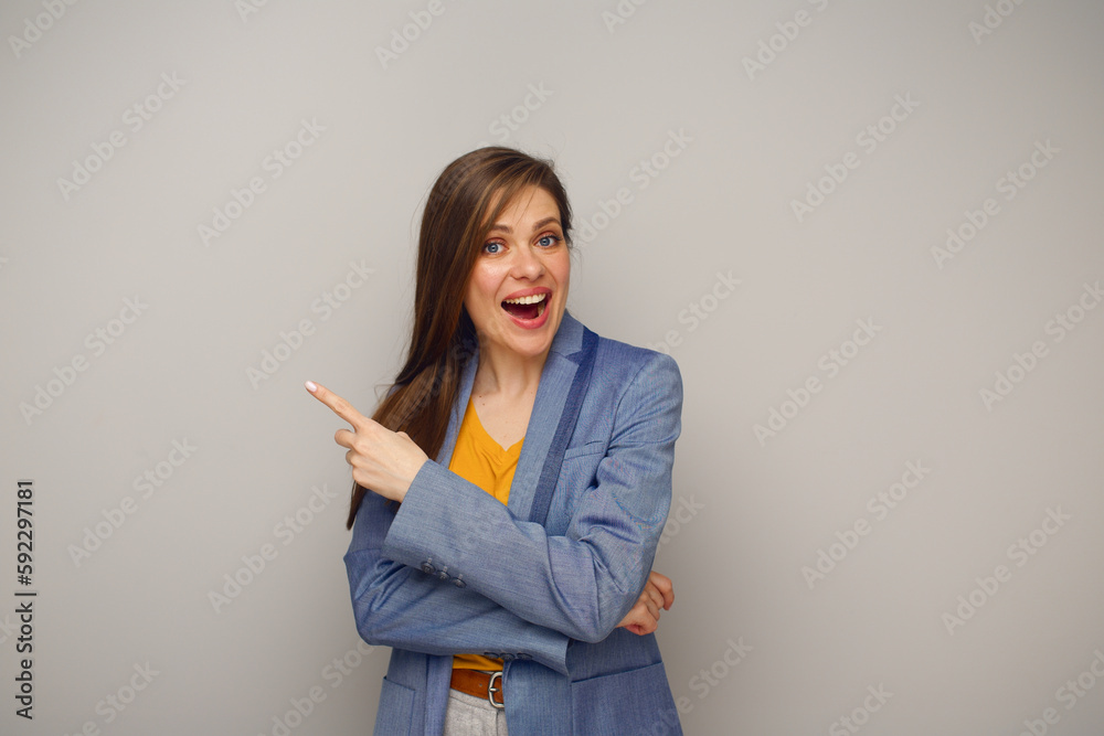 Smiling woman in blue business suit pointing finger at side, isolated female portrait. Smiling woman in blue business suit pointing finger at side, isolated female portrait.