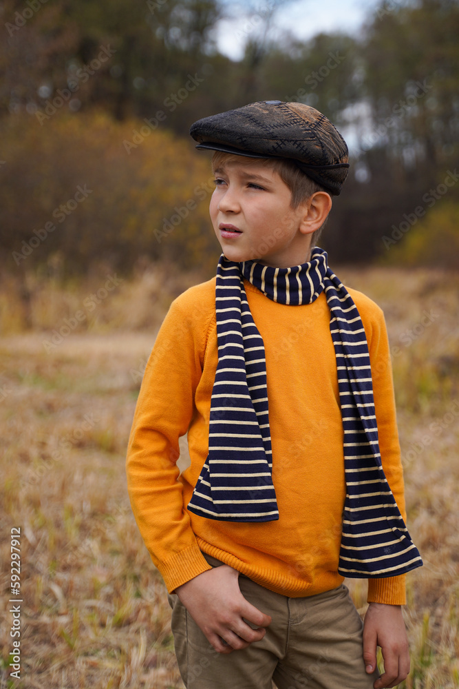 A fashionable guy in vintage clothes in the autumn forest