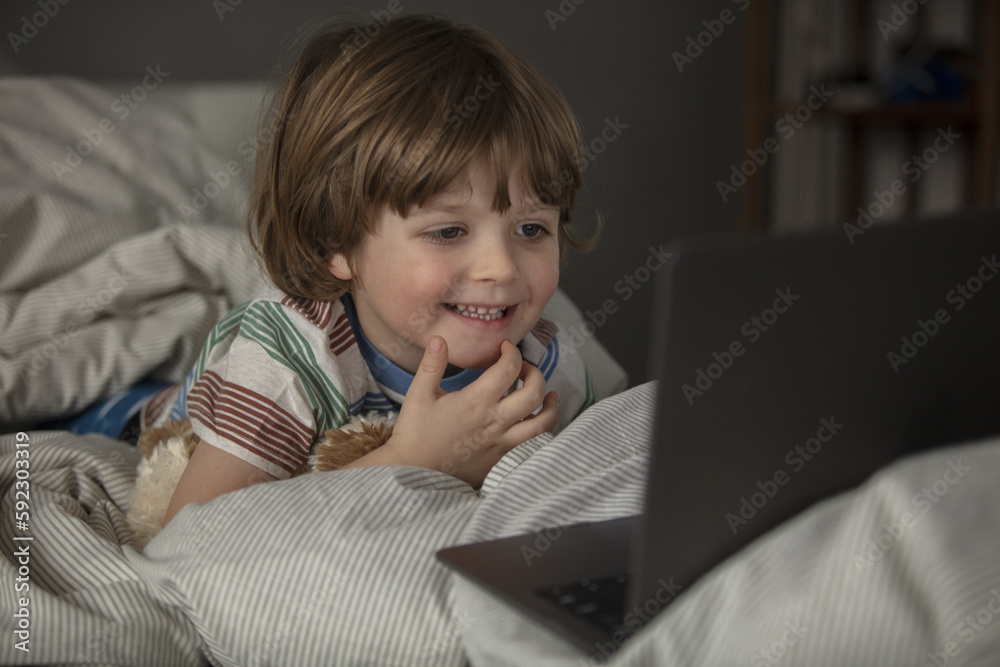 The child watches cartoons on the laptop before a sleep.Baby have a call and talking before a sleep on the the laptop. Toddler watch a movie before a sleep. The child watches cartoons on the laptop before a sleep.Baby have a call and talking before a sleep on the the laptop. Toddler watch a movie before a sleep.