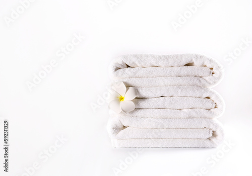 Stack of neatly folded towels isolated on white background. Showcase of a cozy bathroom or spa setting against. Studio shot, close up, copy space.