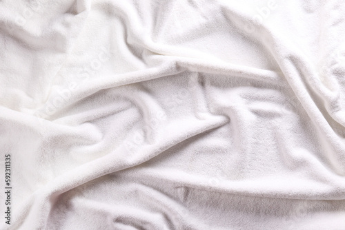 Macro shot white towel with visible fiber structure and wrinkles. A detailed close-up of towel fabric texture in monochromatic hues. Copy space for text, background.