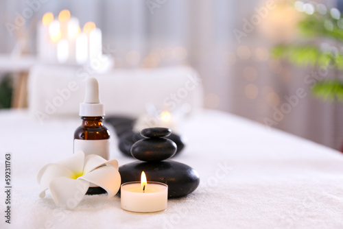 Massage room concept. Stone therapy attributes for cosmetic procedures on a massage table. Symbolic objects for spa salon. Close up  copy space for text  top view  background.