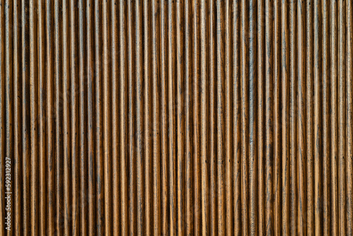 Dark wood material wall with 3d vertical line pattern. Background and texture photo.