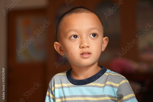 Asian boy looking up at the room