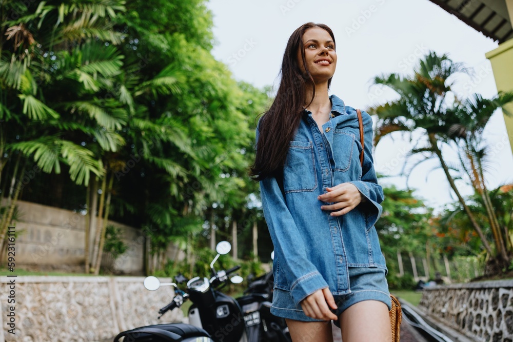 Portrait woman brunette smile with teeth running down the street against backdrop of palm trees in the tropics, summer vacations and outdoor recreation, the carefree lifestyle of a freelance student. Portrait woman brunette smile with teeth running down the street against backdrop of palm trees in the tropics, summer vacations and outdoor recreation, the carefree lifestyle of a freelance student.