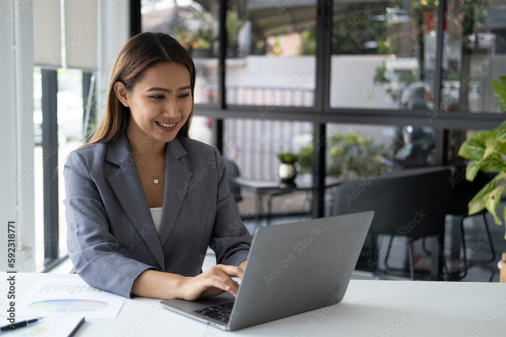 Beautiful confident businesswoman typing on laptop computer while working at her office desk. Beautiful confident businesswoman typing on laptop computer while working at her office desk.