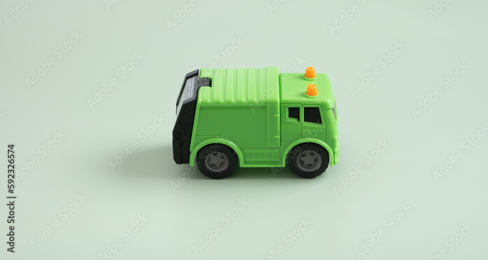 Toy garbage truck and recycle text on a green background