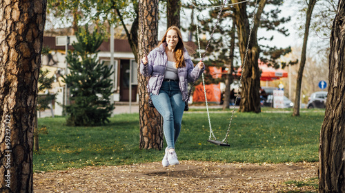 Teens Mood swings: Hormonal changes can cause mood swings, irritability, and emotional outbursts in teenage girls. Teenager girl in glasses on swing in city park.