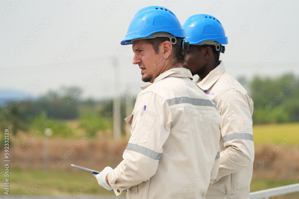 Electrician engineer with white helmet working at a photovoltaic farm, checking and maintenance equipment with instruments at industry solar power. Electrician engineer with white helmet working at a photovoltaic farm, checking and maintenance equipment with instruments at industry solar power.