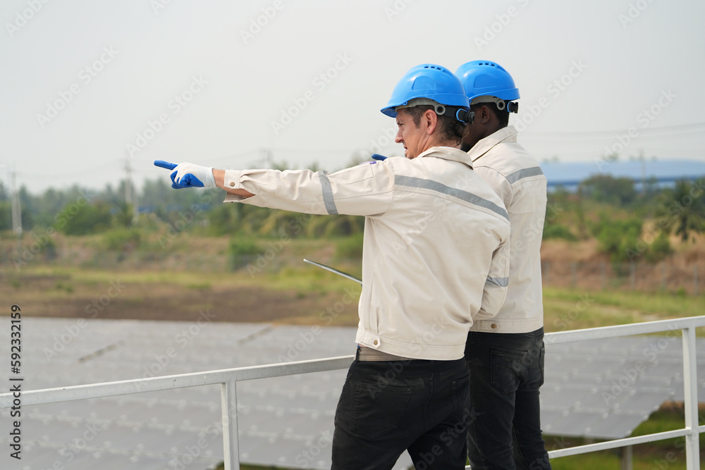 Electrician engineer with white helmet working at a photovoltaic farm, checking and maintenance equipment with instruments at industry solar power. Electrician engineer with white helmet working at a photovoltaic farm, checking and maintenance equipment with instruments at industry solar power.