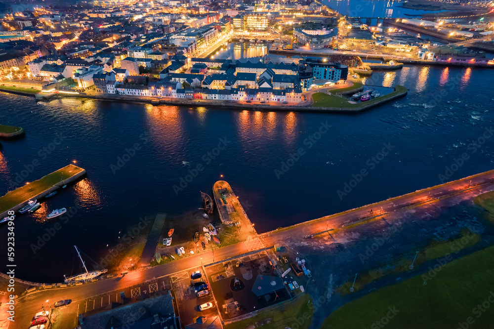 Illuminated port town at night. Aerial view on River Corrib and Galway ...