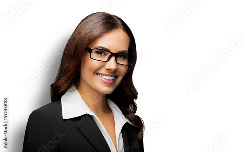 Portrait of happy smiling young businesswoman in eye glasses spectacles, black confident suit, against white background. Business woman in eyeglasses at studio.
