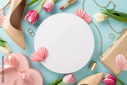 Glamorous Mother's Day idea. Flat lay top view concept with high-heels, handbag, gift box, tulip flowers, lipstick, makeup brushes, and earrings on a pastel blue background with empty circle