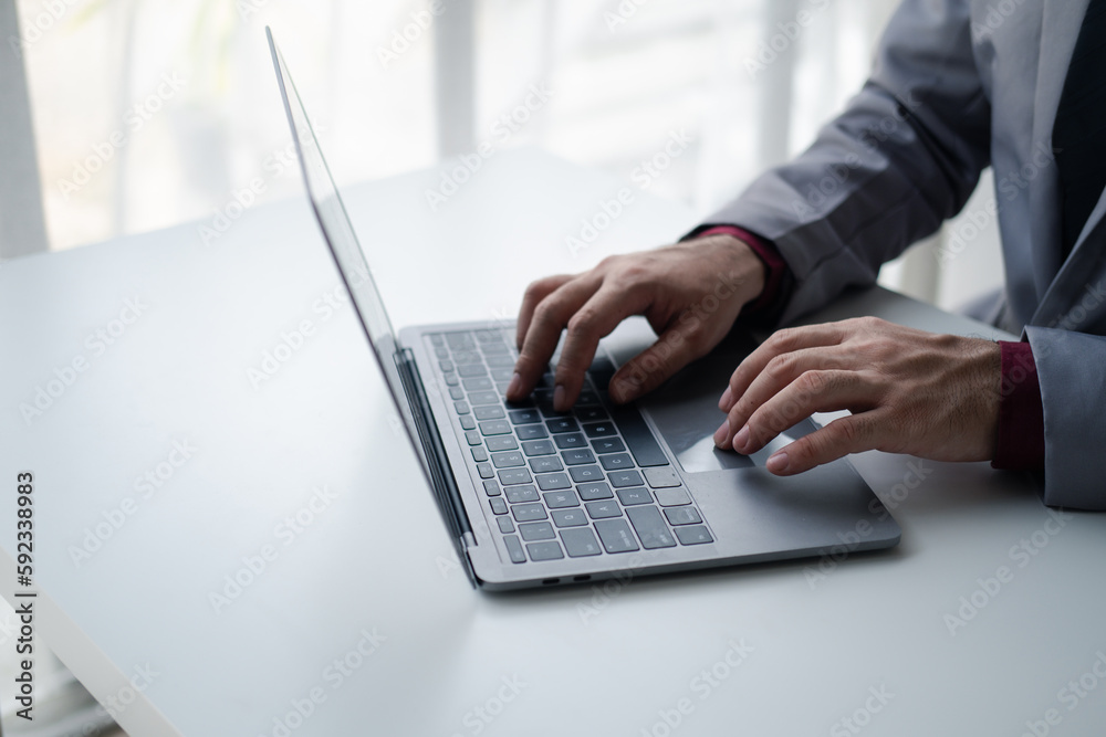 Close up view of businessman typing on laptop computer while working at office desk. Close up view of businessman typing on laptop computer while working at office desk.