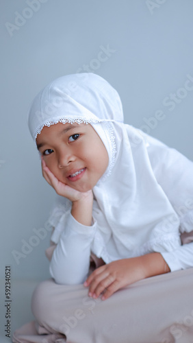 moslem young girl wearing hijab with cute and beautiful pose over gray background.
