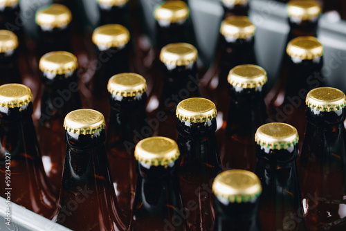 Brewery plant production line with Glass bottles of beer on dark background, top view