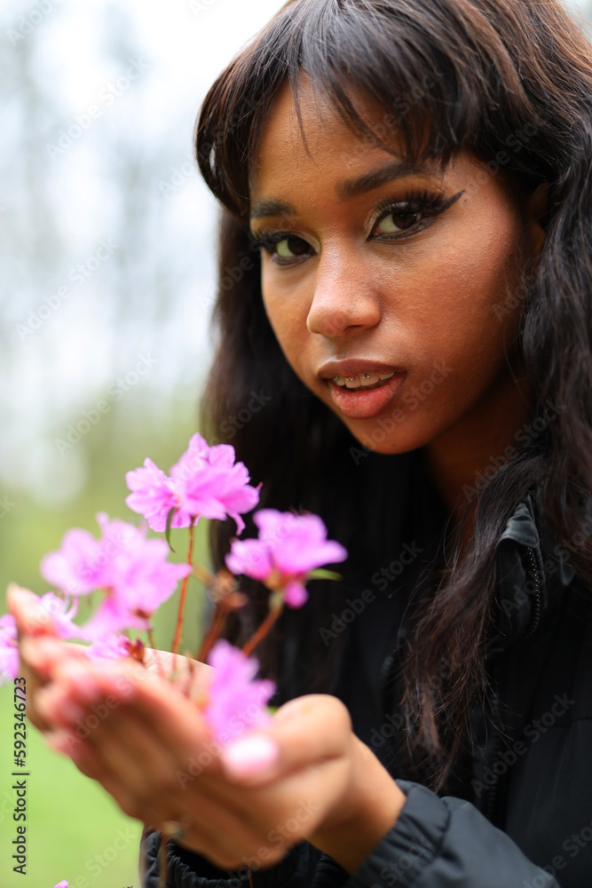 A handful of delicate pink flowers in the hands of an African woman. A handful of delicate pink flowers in the hands of an African woman.