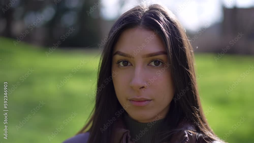 Closeup face of a young brunette adult girl staring at camera. Portrait of one woman Closeup face of a young brunette adult girl staring at camera. Portrait of one woman