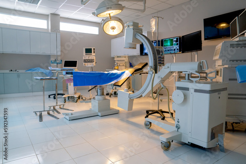Wide shot of empty operation room with no people and view through clear mirror contain tools and instrument to support for treatment the patient.