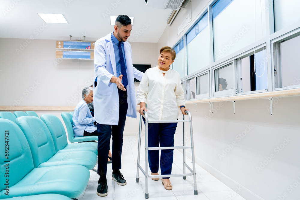 Obraz premium Portrait of Caucasian doctor help to take care and support senior patient woman with walker to walk in front of pharmacy counter in hospital.