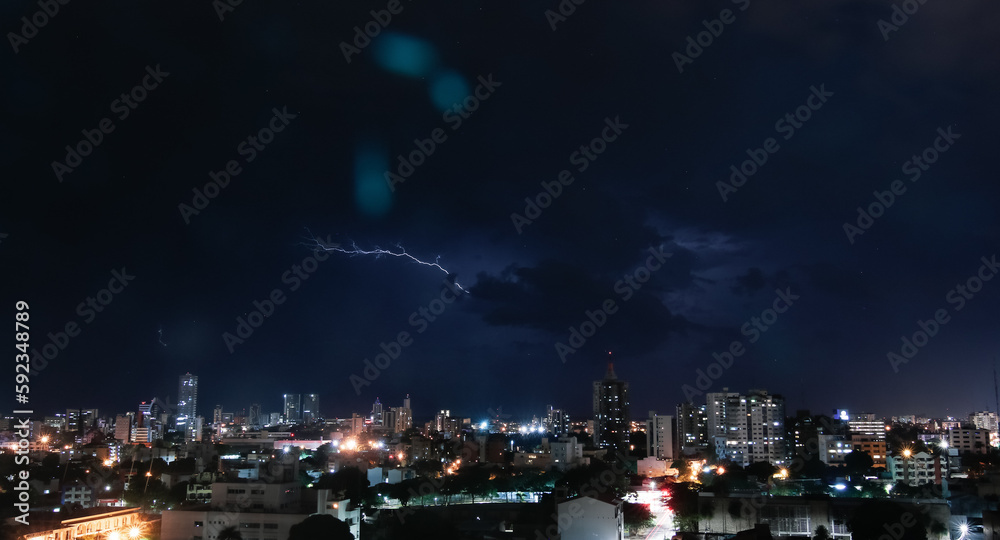 Thunderstorm with lightning in a cloudy sky over the high buildings of city SANTA CRUZ DE LA SIERRA - BOLIVIA 