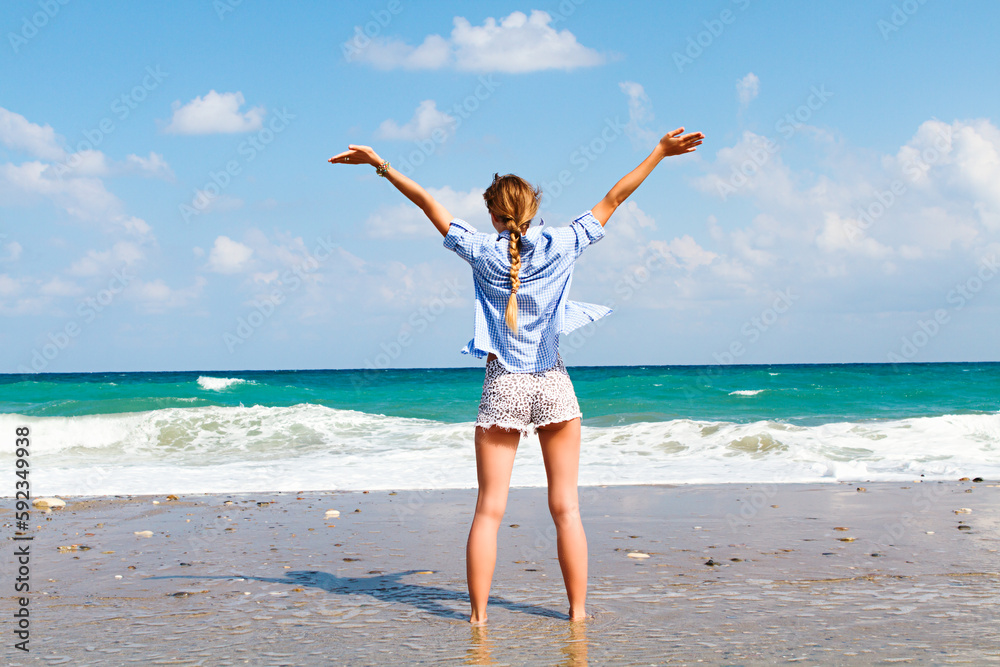 the concept of freedom and independence - a happy girl stands on a sandy beach and the concept of freedom and independence - a happy girl stands on a sandy beach and