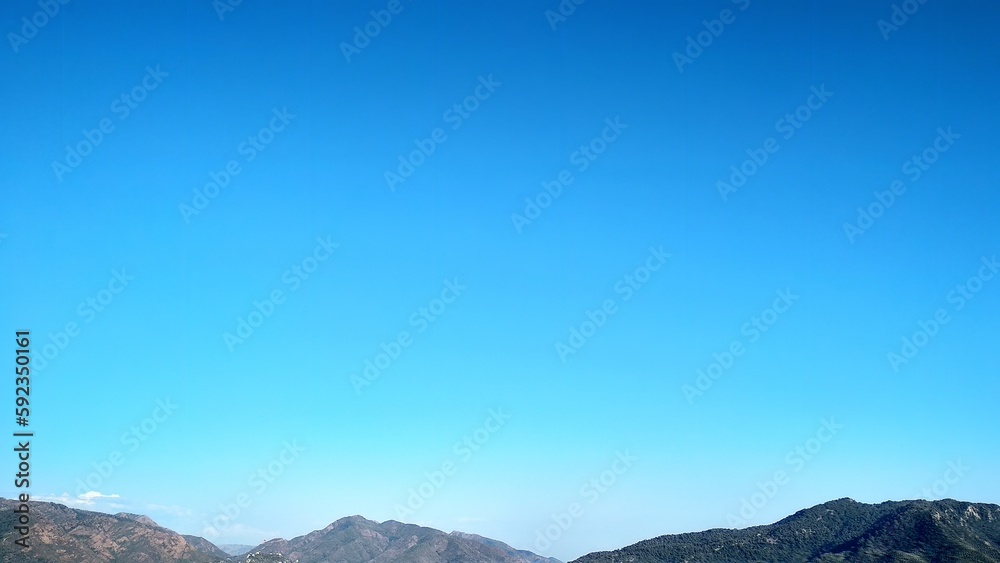 blue sky with white clouds and mountains below, background with blank print background