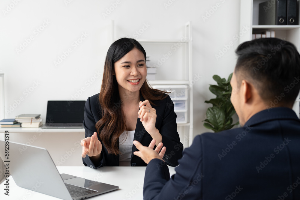 Smart Asian businesswoman presenting her idea to her coworker in the meeting room. Smart Asian businesswoman presenting her idea to her coworker in the meeting room.