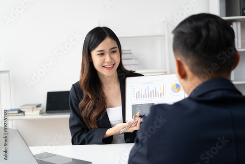 Smart Asian businesswoman presenting her idea to her coworker in the meeting room.