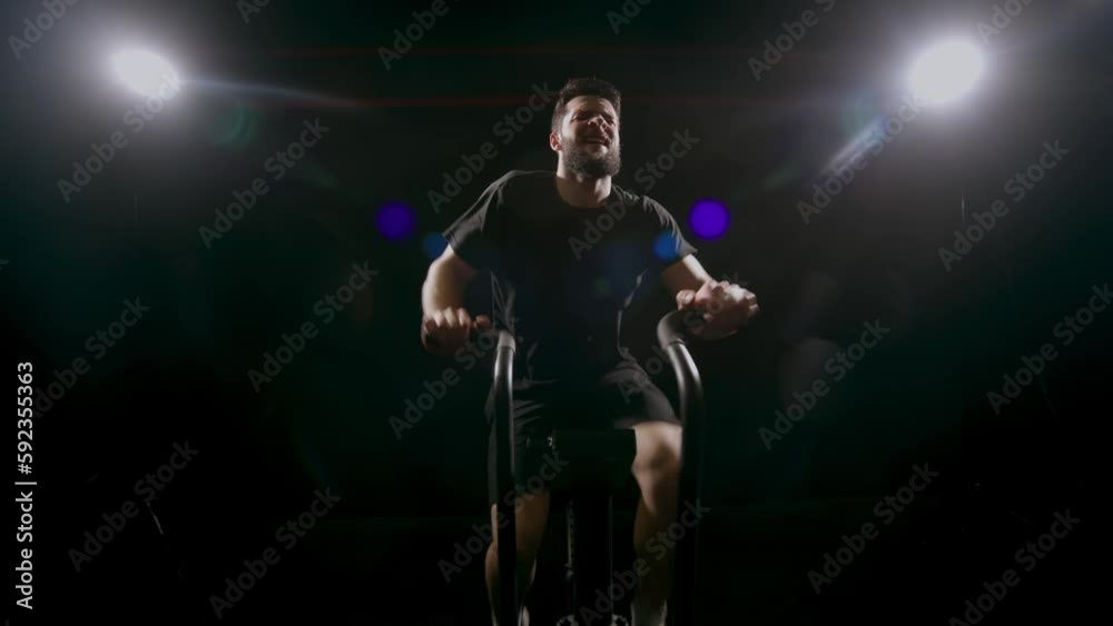 Exercise bike, fitness and sweat with a man athlete in a gym for a cardiovascular workout. Elliptical machine and breathing with a male cycling to increase health, cardio or endurance Exercise bike, fitness and sweat with a man athlete in a gym for a cardiovascular workout. Elliptical machine and breathing with a male cycling to increase health, cardio or endurance