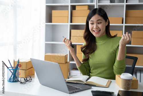 Overjoyed young online business shop owner feeling suprise and celebrate her unexpacted goal in her room.