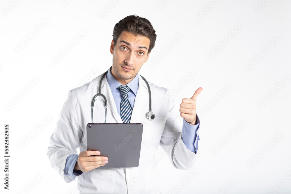 Positive handsome male doctor in medical gown and stethoscope pointing on free space isolated on white background. Copy space and place for text in medical Positive handsome male doctor in medical gown and stethoscope pointing on free space isolated on white background. Copy space and place for text in medical
