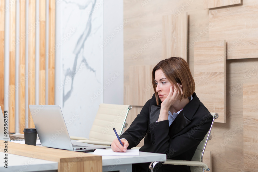 Serious business woman in black suit working in modern office Serious business woman in black suit working in modern office